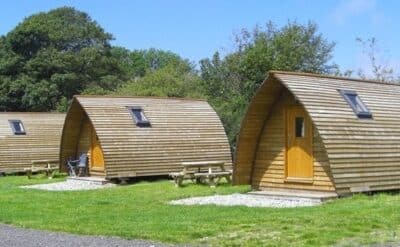 Row of timber glamping pods with picnic benches, Snowdonia, north Wales