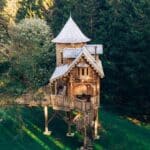 Fairytale treehouse on stilts with a turret roof in woodland, Hesleyside, Northumberland
