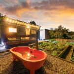 Cabin with festoon lights and a heart-shaped outdoor bath at sunset, Snowdonia