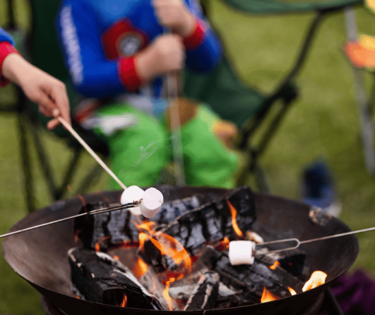 Children sat around a campfire at Meadow Falls campsite