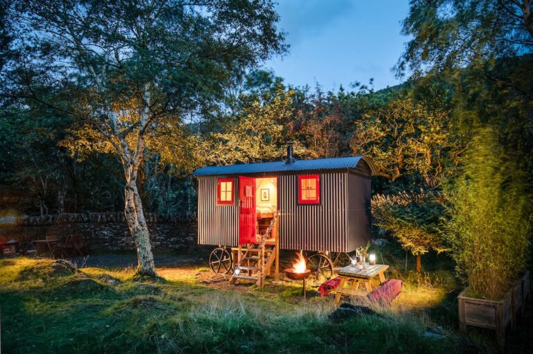 a shepherds hut lit up at dusk in wales