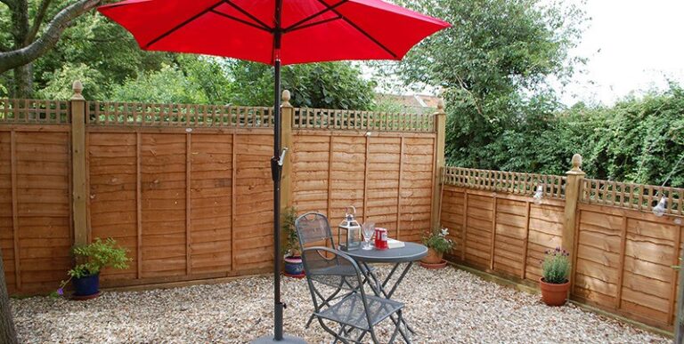 Outdoor table and red umbrella at To Rest A While Glamping Somerset