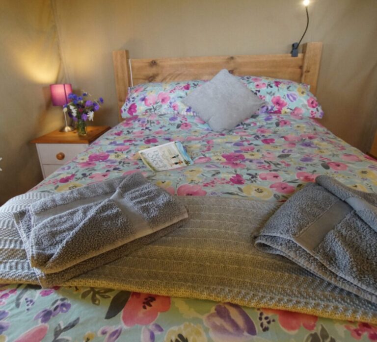 Bed in a safari tent at Village Farm Hideaway Leicestershire