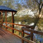 Log cabin balcony overlooking the lake at sunset, Kingfisher Lakes, East Yorkshire