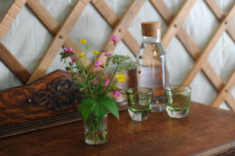 Spring water and wildflowers on the table inside a yurt at Redwood Valley