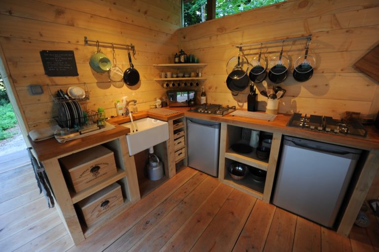 The shared woodland kitchen at Redwood Valley, with gas hobs, fridges and hanging pans