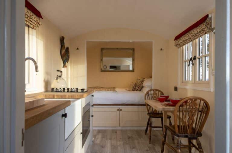 Bright interior of an Abbey Farm shepherd's hut with kitchen and window dining table