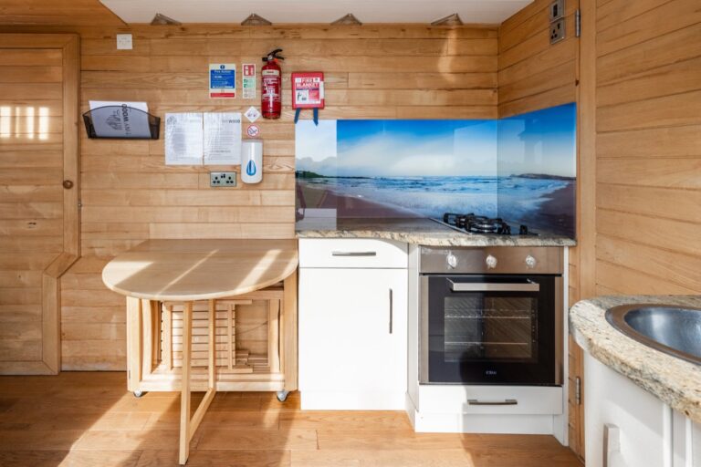 Fitted kitchen with oven and fold-away dining table inside Tinywood One